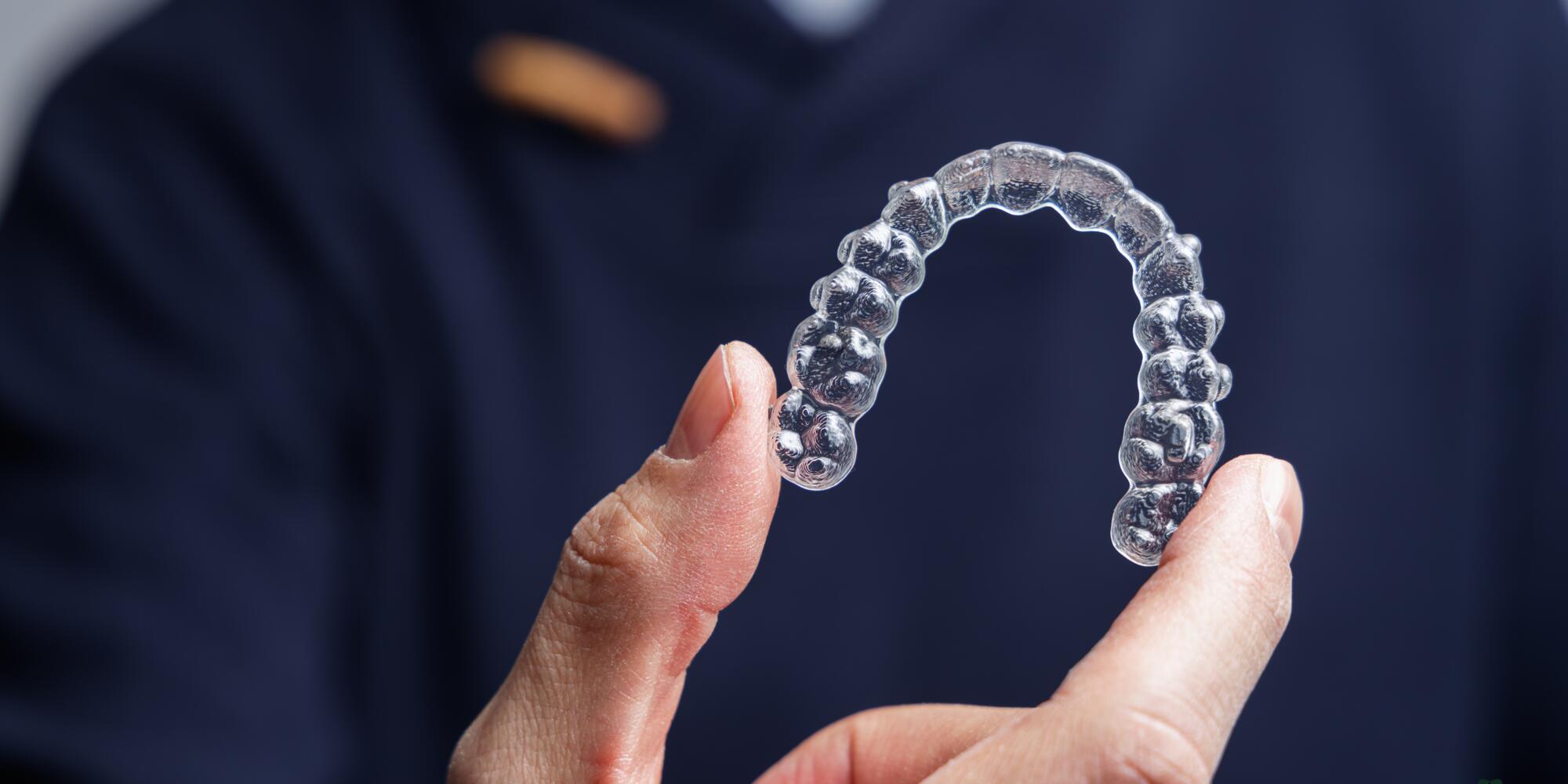clear aligners at The Pines Dental Centre a man holding a clear aligners