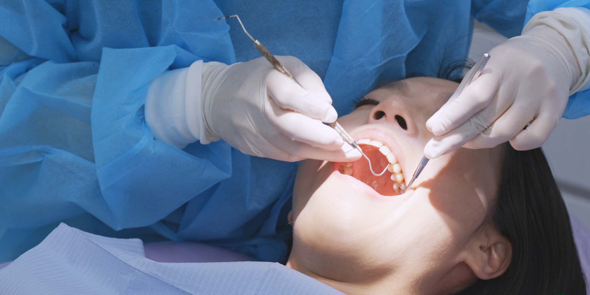 Oral Surgery at The Pines Dental Centre Dentist wearing protective gear performing a dental procedure on a patient